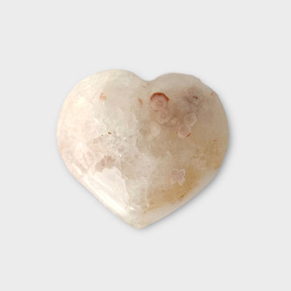 A close-up of a Flower Agate Heart on a white background, emphasizing its unique floral-like inclusions and soft pastel hues.