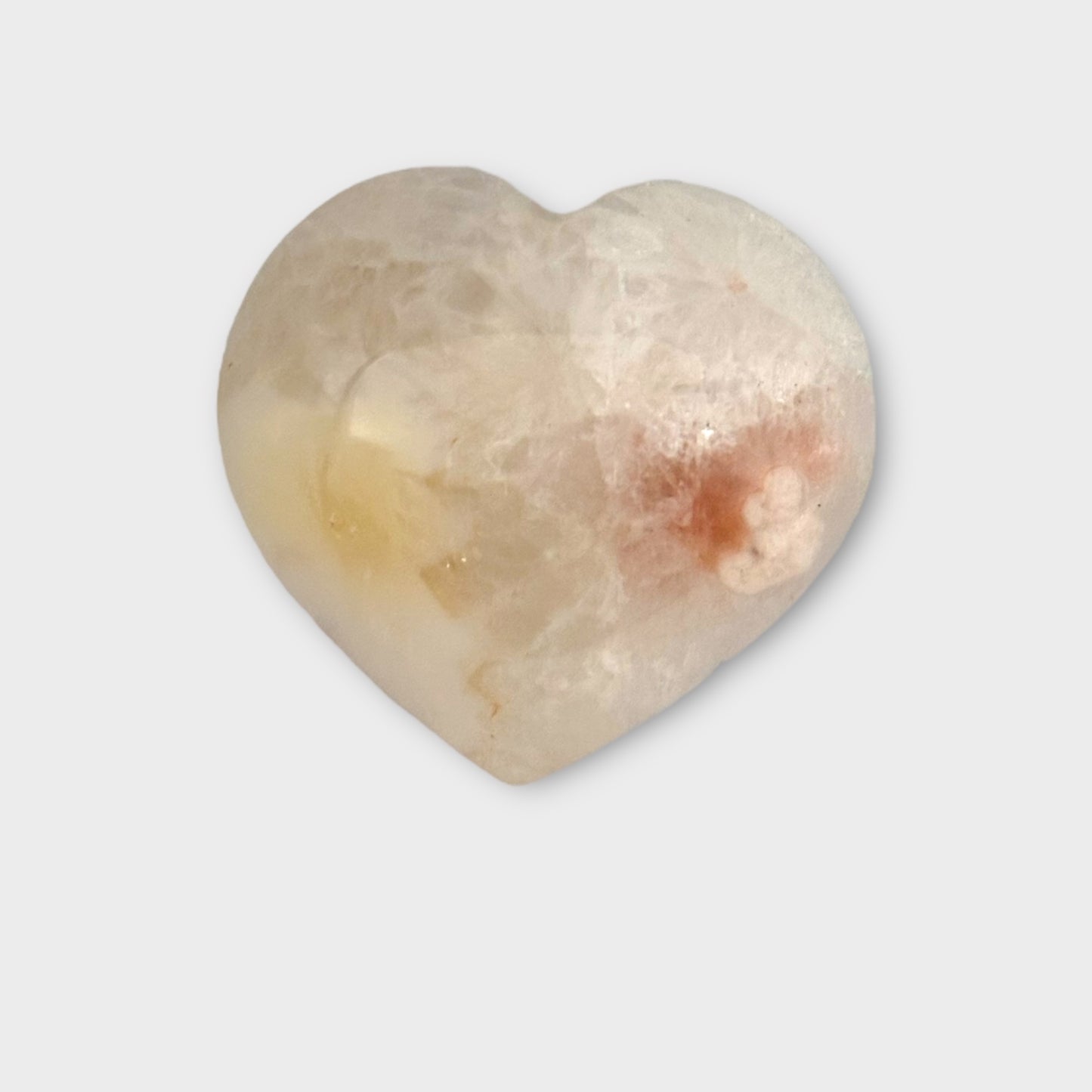 A Flower Agate Heart displayed on a plain white background, showcasing its delicate floral patterns and polished finish.