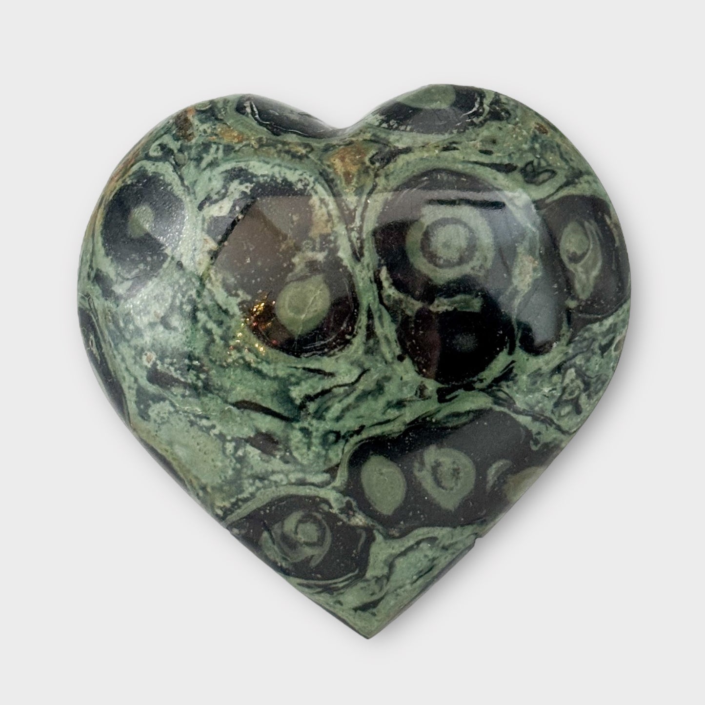 A Kambaba Jasper Heart displayed on a white background, showcasing its smooth surface and unique green and black patterns.