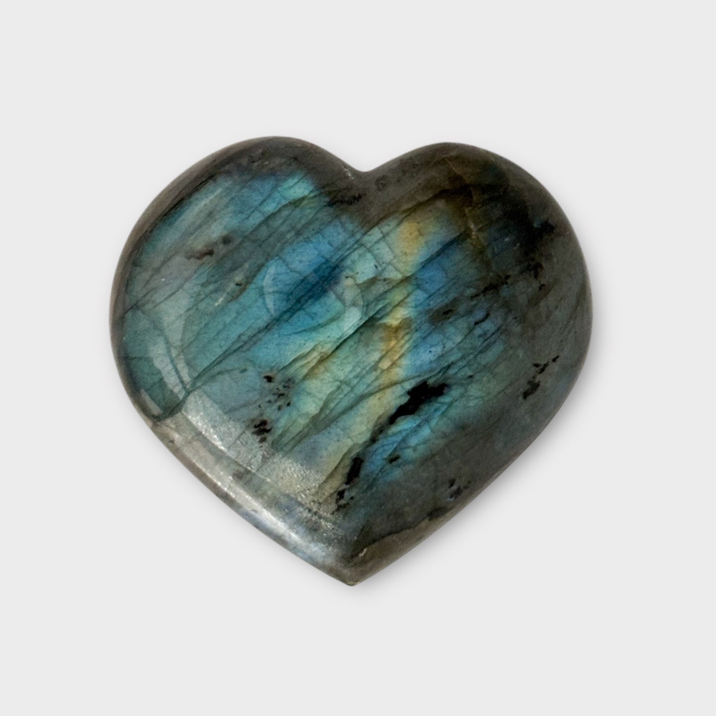 Side view of a Labradorite Heart on a white background, showcasing its smooth edges and iridescent flashes.