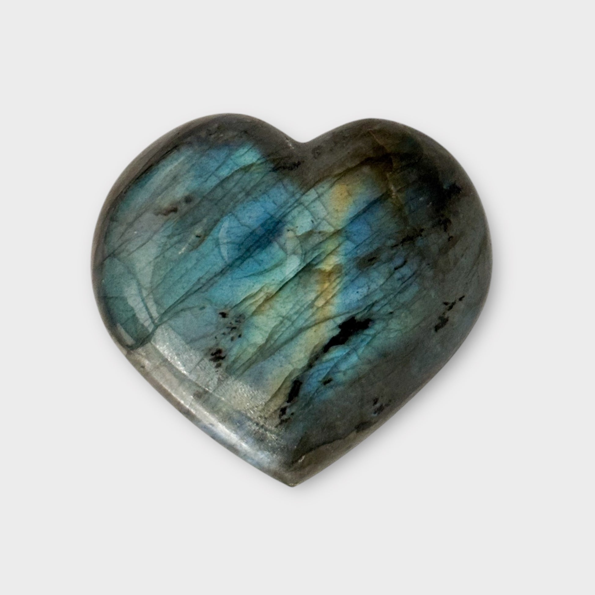 Side view of a Labradorite Heart on a white background, showcasing its smooth edges and iridescent flashes.