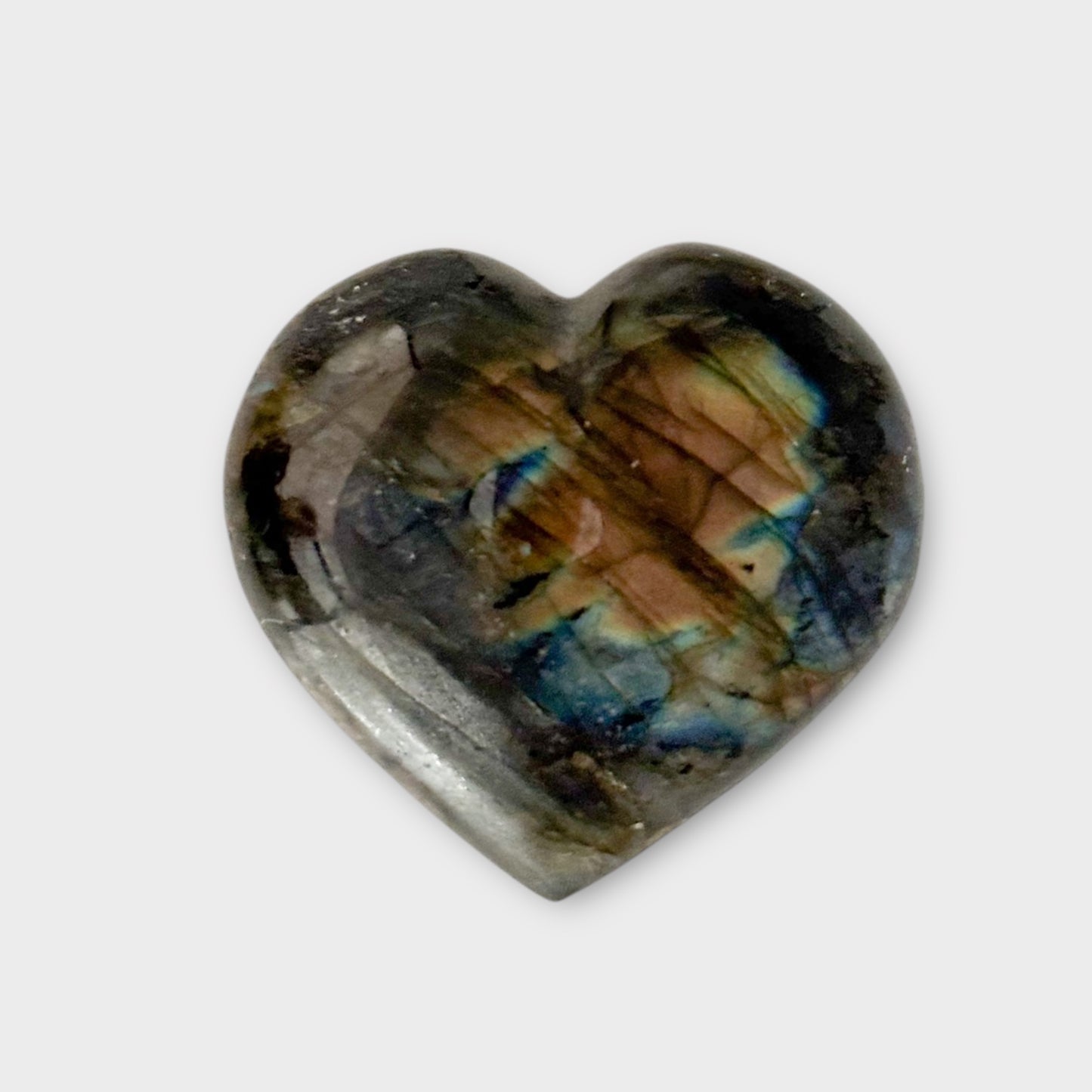 A Labradorite Heart photographed on a white background, highlighting its radiant iridescence and smooth finish.