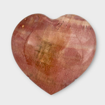 A pink Polychrome Jasper Heart displayed on a white background, emphasizing its smooth, glossy surface and natural pink tones.