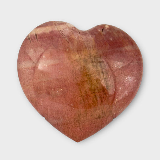 Close-up of a pink Polychrome Jasper Heart on a white background, showcasing its unique patterns and radiant pink hues.