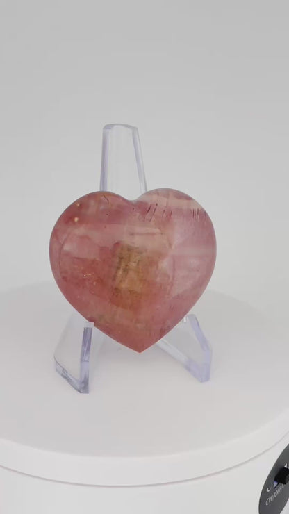 A rotating video of a polished pink Polychrome Jasper Heart, showcasing its smooth surface, soft pink tones, and natural patterns.